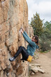 © ADDICTIVE STOCK - A young climber with a chalk bag is gripping onto a steep rock face with concentration, showcasing her bouldering skills