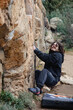 © ADDICTIVE STOCK - A climber with curly hair engages in a challenging boulder problem, showcasing agility and climbing technique