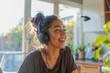 woman laughs as she listens to headphones playing her favourite podcast
