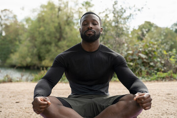 Athletic man meditating in park