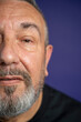 © Cultura Creative - Portrait of serious man with beard against purple background