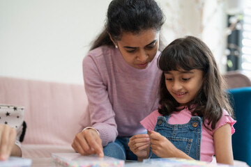 Wall Mural - Mother with daughter playing with beads in living room