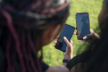 Wall Mural - Close-up of female friends holding smart phones