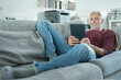 Smiling mature man using digital tablet on sofa