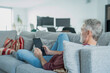 © Cultura Creative - Smiling mature man using digital tablet on sofa
