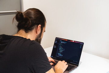 young professional software engineer, it specialist, programmer, working at home and writing code on