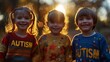 Three cute little kids boys and girls in colorful sweaters with AUTISM text having fun on sunny autumn day.
