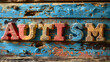 The word  autism written in wooden letterpress type on a vintage wooden background.