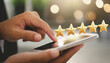 © netsay - close up on customer man hand pressing on smartphone screen with gold five star rating feedback icon and press level three rank (good) for give score point to review the service business concept