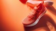 A modern red running sneaker showcased artistically with dynamic lighting on a textured orange background