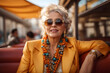 Happy, smiling senior woman in sunglasses on her trip to europe, retired fashionable, stylish mature solo female traveler in cafe, restaurant. Retirement travel and leisure activity for elderly people