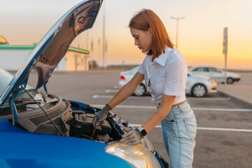 Wall Mural - woman on the road with a car with an open hood, car breakdown.