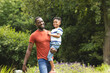 © Wavebreak Media - African American father carries his son on a sunny day in the park with copy space