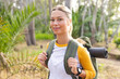 © Wavebreak Media - Young woman with a backpack and yoga mat prepares for a hike in a forest on a hike