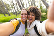 © Wavebreak Media - Two women are taking a selfie on a hike, one with blonde hair and the other with curly hair