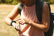 © Wavebreak Media - Young biracial woman checks her smartwatch outdoors on a hike