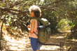© Wavebreak Media - A young biracial woman hikes through a sunlit forest