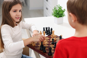 Canvas Print - Cute children playing chess at table in room