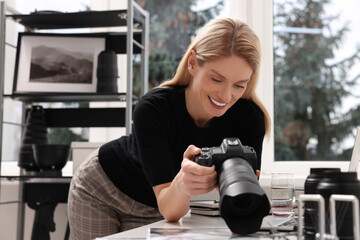 Canvas Print - Professional photographer with digital camera at table in office