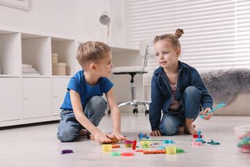 Wall Mural - Cute little children playing on warm floor at home. Heating system