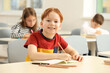 © New Africa - Portrait of smiling little boy studying in classroom at school