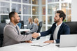 © New Africa - Lawyer shaking hands with client at table in office, selective focus