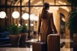 Back view of a young woman with a suitcase in a hotel lobby. Travel and business concept. with copy space. 