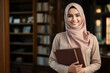 © Sunny - A young Muslim woman with her head covered stands in the library among books. Islamic education concept for women