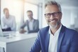 © Fotograf - A man in a blue suit and glasses smiling at the camera. Suitable for business and professional concepts