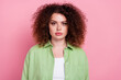 Photo of serious confident pleasant woman with perming coiffure dressed green shirt look at camera isolated on pink color background