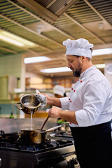 Wall Mural - Professional chef cooking while working in  restaurant.