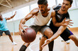 © Marko Geber - Men playing basketball in indoor gym