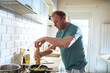 © Marko Geber - Man preparing meal in the home kitchen