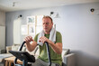 © Marko Geber - Tired middle aged man working out at home on fitness bike