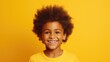 A young boy with an afro smiling at the camera. Ideal for diverse and joyful concepts
