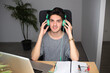 Young man using headphones and laptop at home