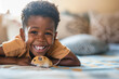 Portrait of little cute black curly boy holding his pet domestic mouse