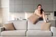 © Prostock-studio - Happy lady arranging pillows on stylish couch at home