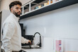 © qunica.com - Stylish man in a modern kitchen enjoying a morning coffee.
