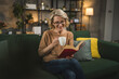 © Miljan Živković - One woman mature caucasian female read book at home wear eyeglasses