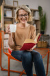 © Miljan Živković - One woman mature caucasian female read book at home wear eyeglasses