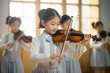 Hochbegabte asiatische Kinder spielen Geige, chinesisches Mädchen