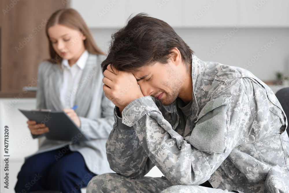 Sad male soldier on appointment with psychologist at office