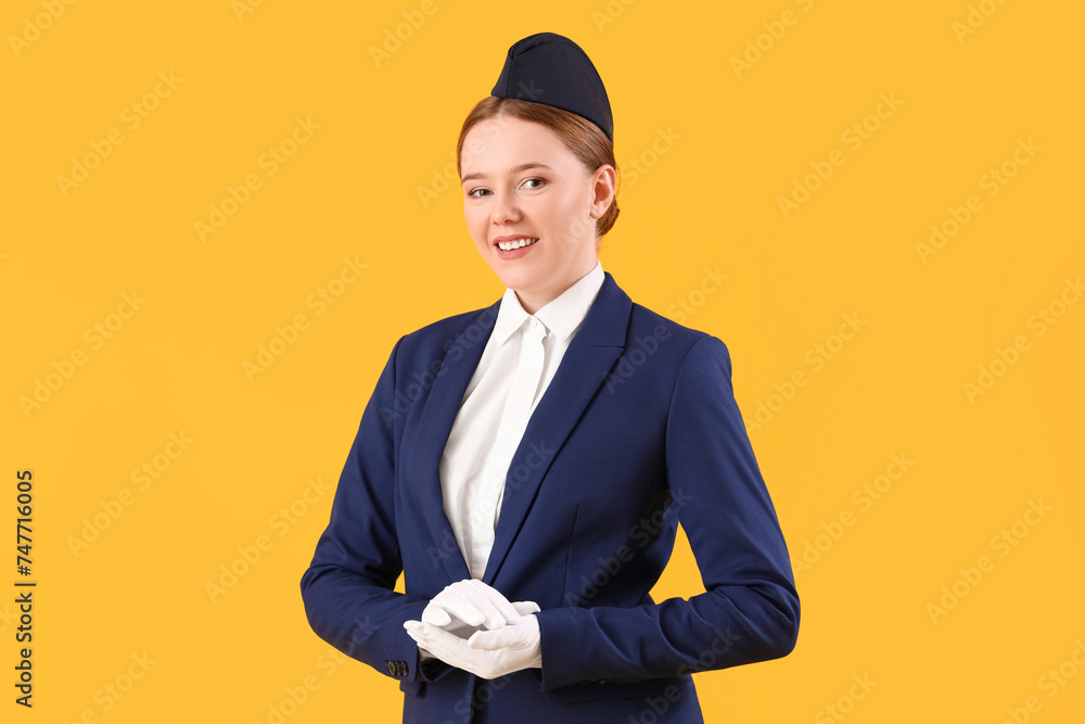 Young stewardess on yellow background