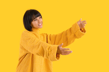 Sticker - Young woman opening arms for hug on yellow background