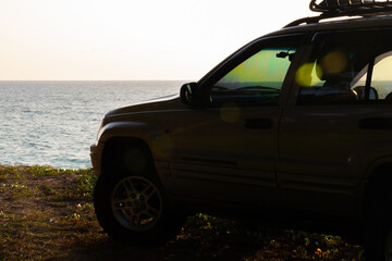 Phuket Thailand January 22,2024:Brown American SUV Jeep Grand Cherokee WJ 2002 on the beach sunset sky background in Phuket island Thailand,Travel and camping concept transportation background