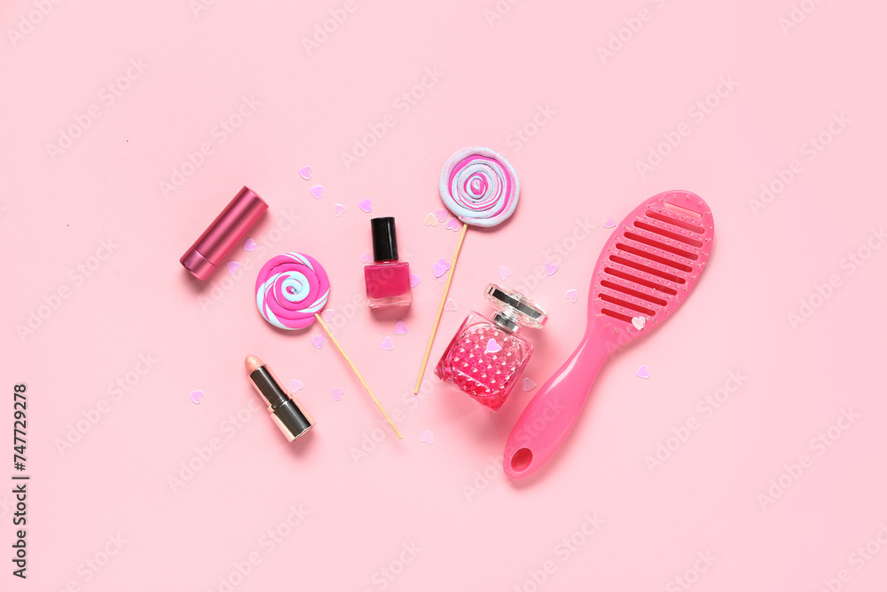 Composition with decorative cosmetics, hair brush and lollipops on pink background. Valentine's Day celebration