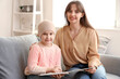 Little girl after chemotherapy with her mother reading book at home. International Childhood Cancer Day