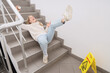 © Pixel-Shot - Young woman fell down on wet steps in stairway. Trauma concept
