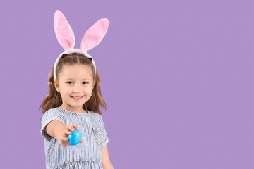 Poster - Cute little girl in bunny ears with Easter egg on purple background